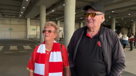 BBC A man and a woman outside a football stadium.