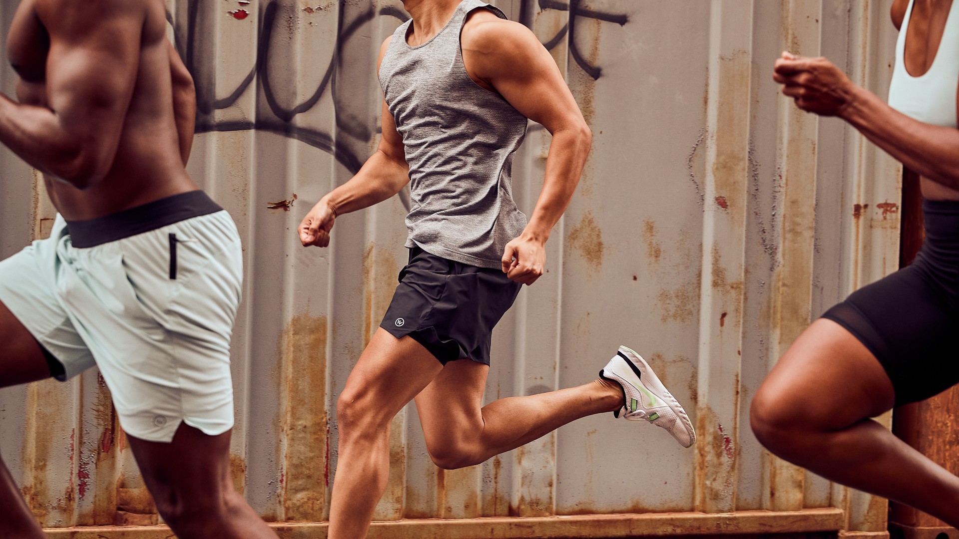 Three men jogging along a street