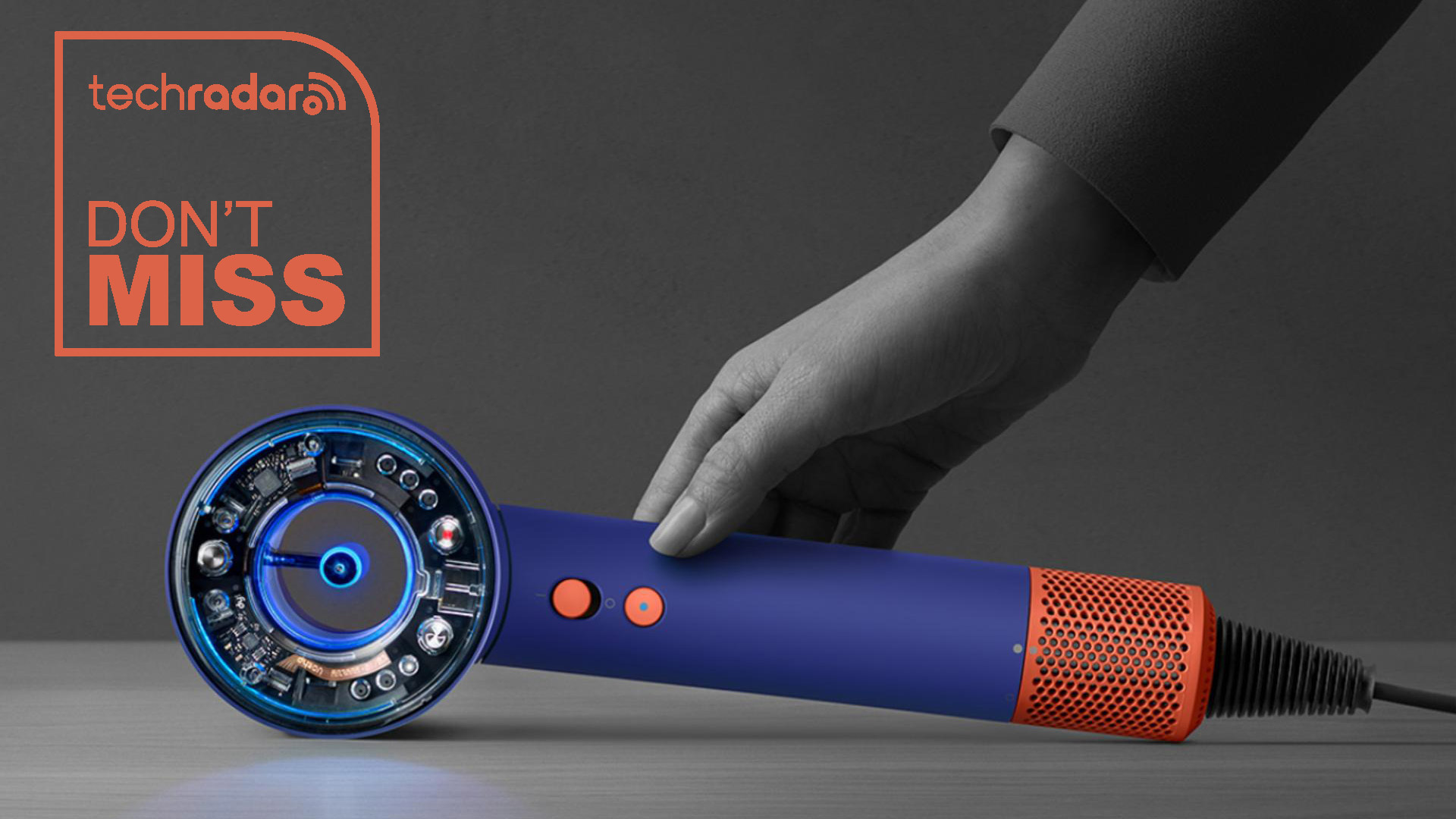 Dyson Supersonic Nural hair dryer lying on its side and viewed from the rear. A hand is seen in black and white with 